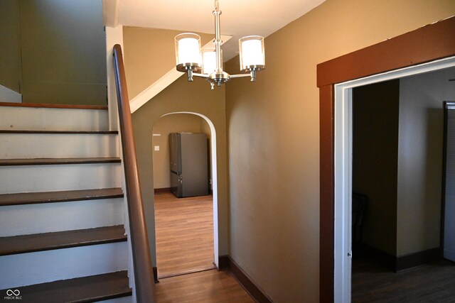 staircase featuring a chandelier and hardwood / wood-style flooring