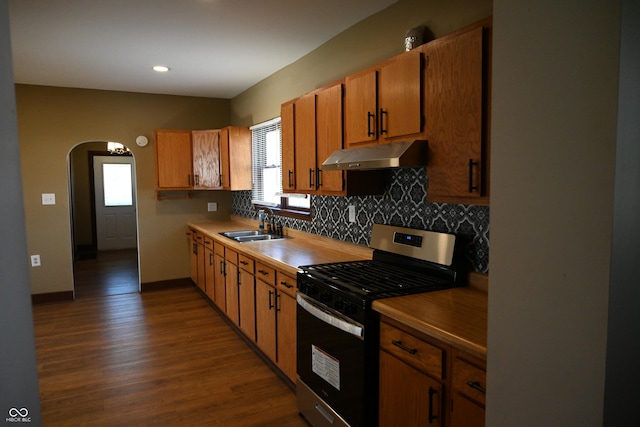 kitchen featuring decorative backsplash, stainless steel gas stove, dark hardwood / wood-style floors, and sink