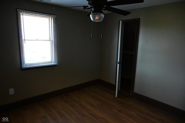 spare room with dark hardwood / wood-style flooring and ceiling fan