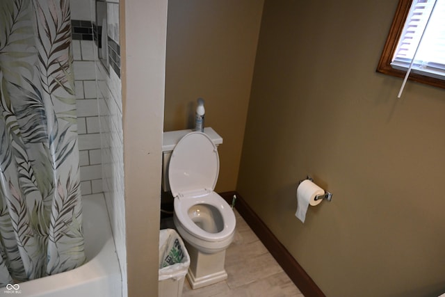 bathroom featuring tile patterned flooring, shower / tub combo, and toilet