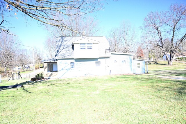 rear view of house featuring a yard