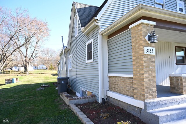 view of side of home with a yard