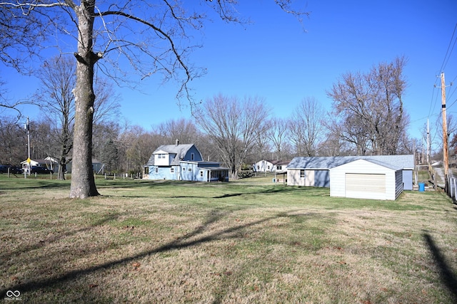 view of yard with a garage and an outbuilding