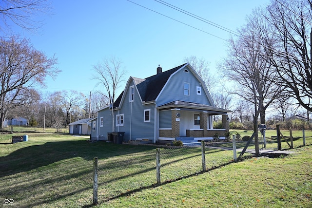 view of side of property with covered porch and a yard