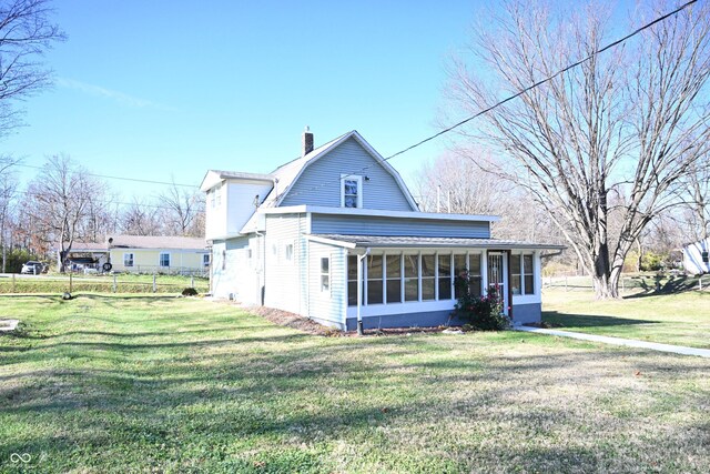 back of house with a sunroom and a yard