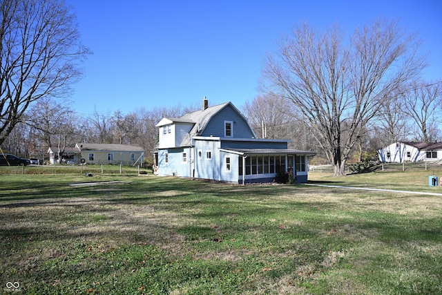 view of home's exterior with a lawn and a sunroom