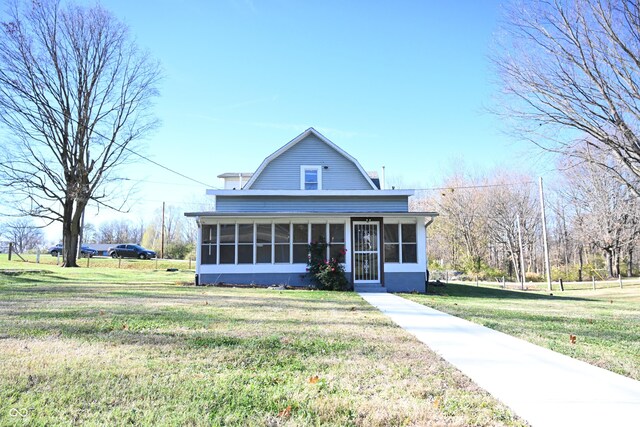 country-style home featuring a sunroom and a front yard