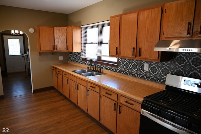 kitchen featuring dark hardwood / wood-style flooring, backsplash, extractor fan, sink, and stainless steel range oven