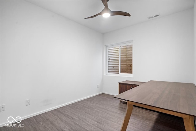 unfurnished office with wood-type flooring and ceiling fan