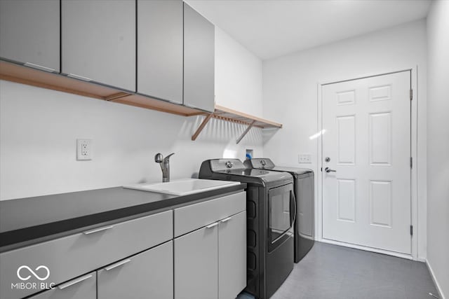 washroom featuring cabinets, sink, and washer and dryer