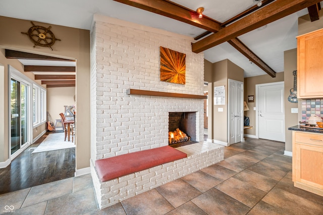 living room with lofted ceiling with beams, dark hardwood / wood-style floors, and a brick fireplace