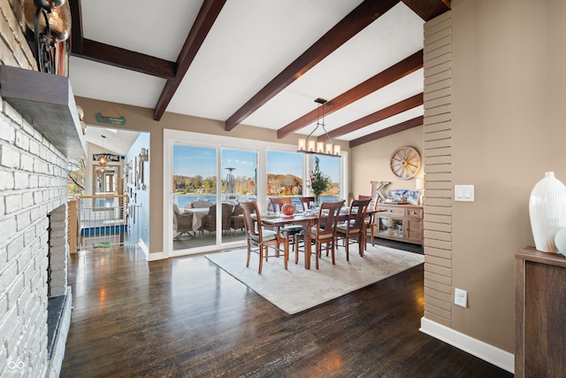 dining room featuring vaulted ceiling with beams, dark hardwood / wood-style flooring, and a brick fireplace