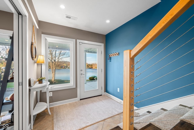 entryway with tile patterned floors and a water view