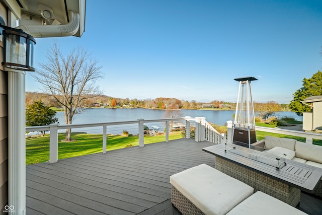 wooden deck with a water view and a lawn