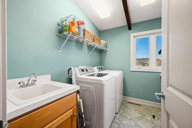 clothes washing area featuring sink, cabinets, separate washer and dryer, a textured ceiling, and light tile patterned floors