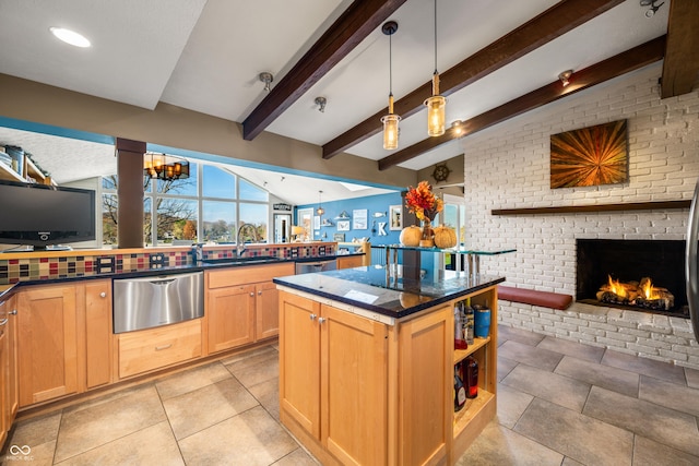 kitchen with lofted ceiling with beams, sink, a fireplace, decorative light fixtures, and a kitchen island