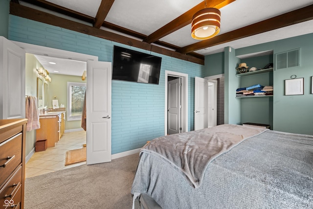 carpeted bedroom with beam ceiling, ceiling fan, and brick wall