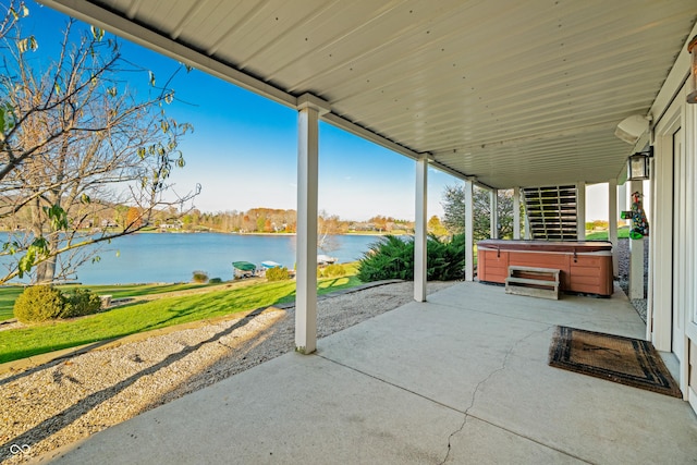 view of patio featuring a water view and a hot tub