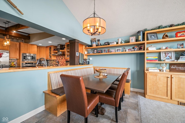 dining space with beamed ceiling, sink, and a chandelier