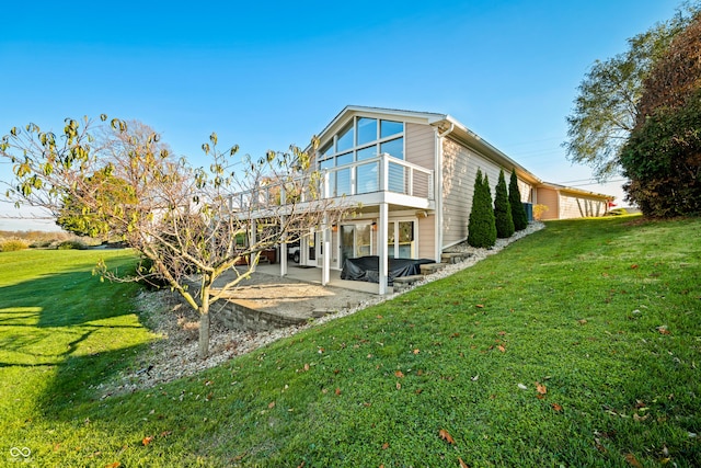 back of house with a patio and a lawn