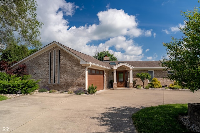 9454 Raintree Dr S, Columbus, IN 47201 - view of front facade featuring an attached garage, brick siding, concrete driveway, and a chimney