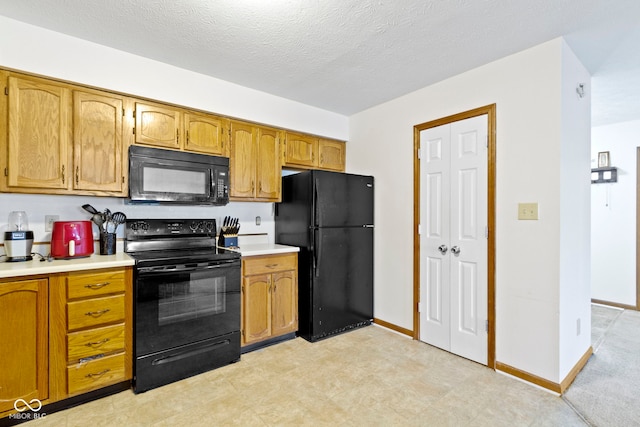 kitchen featuring a textured ceiling and black appliances