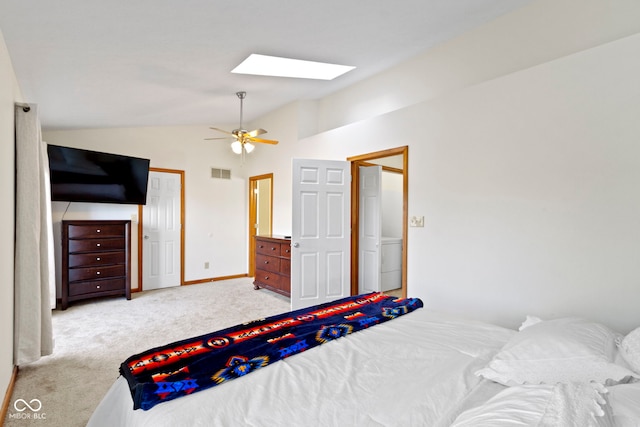 carpeted bedroom with vaulted ceiling with skylight and ceiling fan