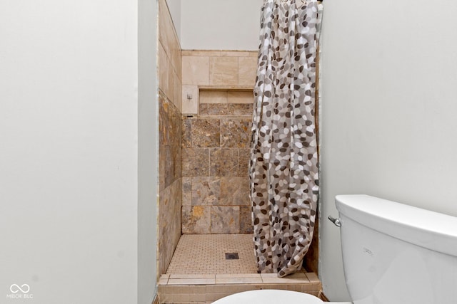 bathroom with a shower with shower curtain and toilet