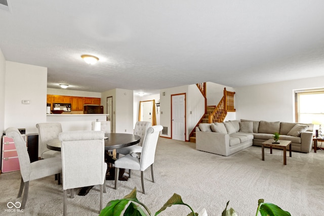 dining space with light colored carpet and a textured ceiling