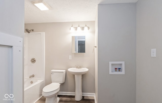 bathroom with a textured ceiling, hardwood / wood-style flooring,  shower combination, and toilet