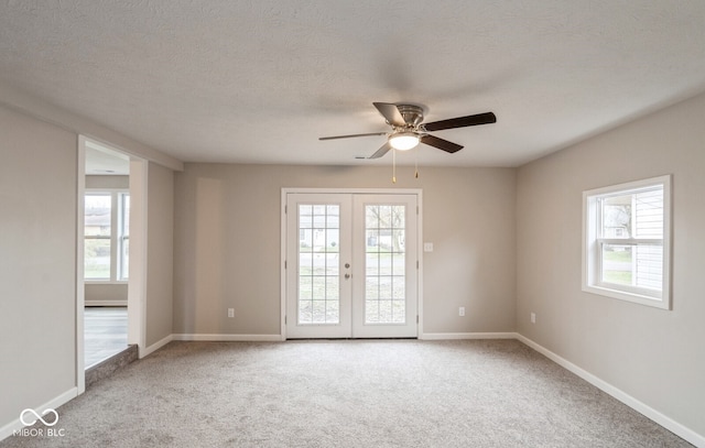 empty room with carpet flooring, plenty of natural light, and french doors