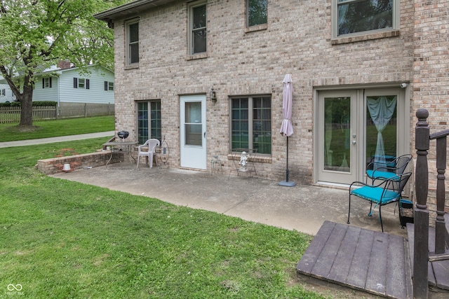 back of property with a patio area and a yard