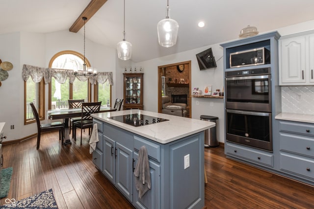 kitchen with white cabinetry, a center island, dark wood-type flooring, stainless steel appliances, and a fireplace