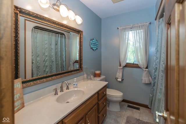 bathroom with toilet, vanity, and tile patterned floors