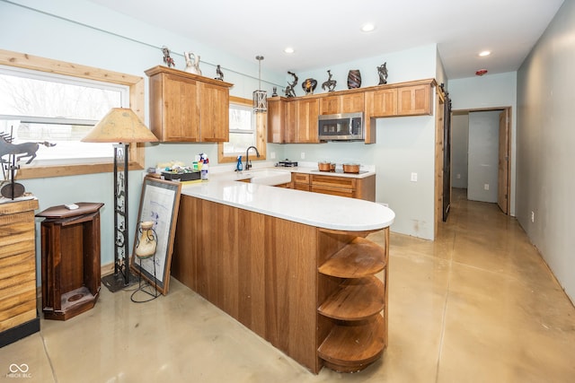 kitchen with decorative light fixtures, kitchen peninsula, and sink