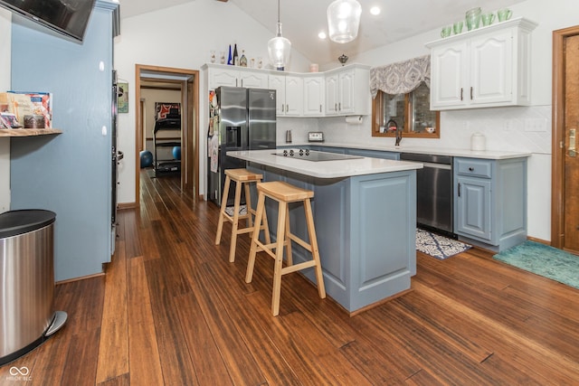 kitchen with lofted ceiling, a center island, white cabinetry, and appliances with stainless steel finishes