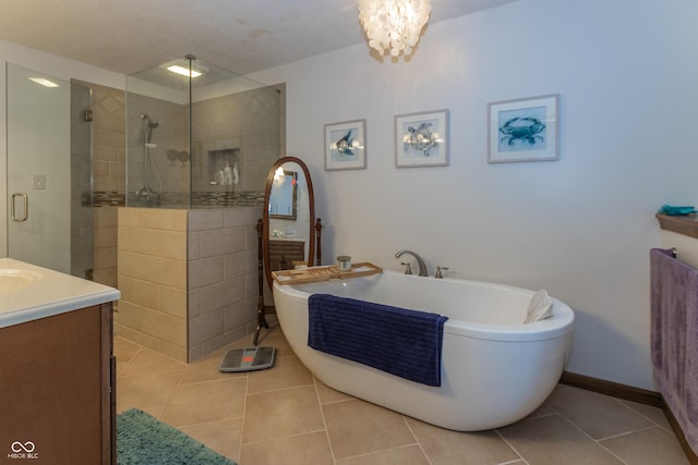 bathroom featuring tile patterned floors, vanity, shower with separate bathtub, and a notable chandelier