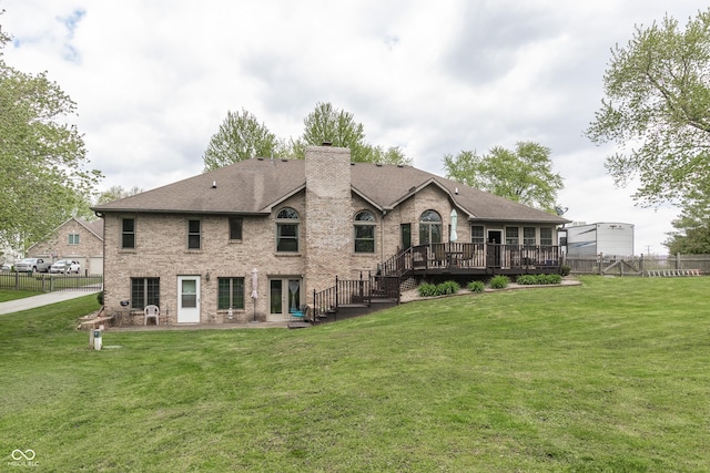 rear view of property with a lawn and a deck