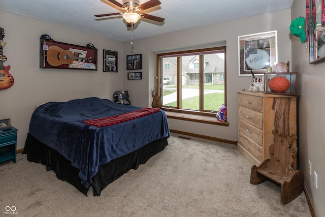 carpeted bedroom featuring a textured ceiling and ceiling fan