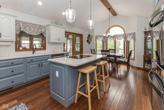 kitchen featuring white cabinets, black electric cooktop, plenty of natural light, and sink