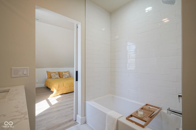 bathroom featuring vanity, hardwood / wood-style flooring, and tiled shower / bath