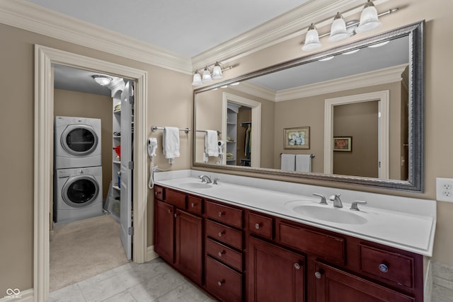 bathroom featuring tile patterned flooring, vanity, stacked washer / dryer, and ornamental molding