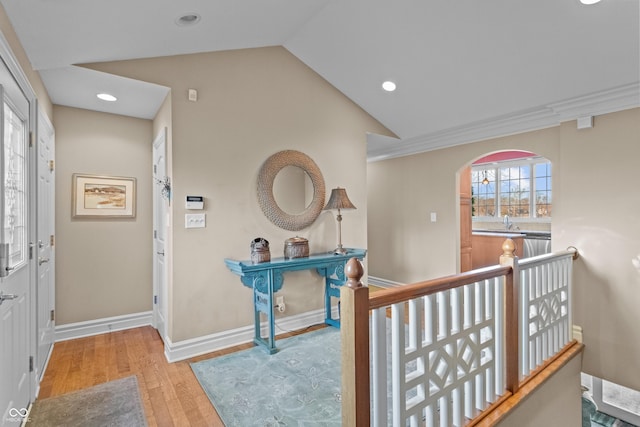 hall featuring light hardwood / wood-style flooring, lofted ceiling, and sink