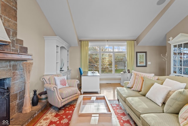 living room with a fireplace, hardwood / wood-style floors, and lofted ceiling