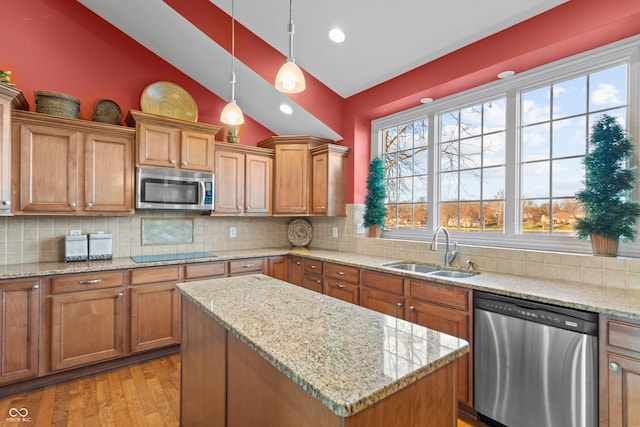 kitchen with stainless steel appliances, sink, light hardwood / wood-style flooring, hanging light fixtures, and lofted ceiling