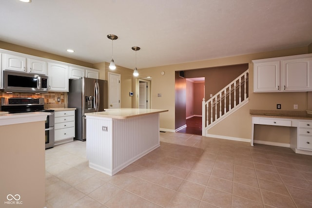 kitchen with white cabinetry, hanging light fixtures, decorative backsplash, a kitchen island, and appliances with stainless steel finishes