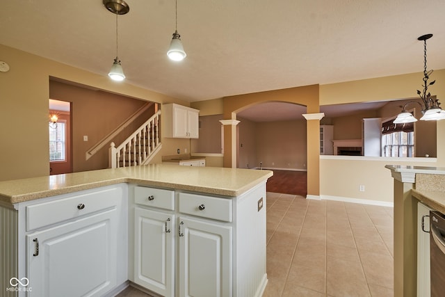 kitchen featuring pendant lighting, plenty of natural light, white cabinetry, and kitchen peninsula