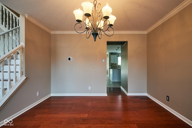 spare room featuring a chandelier, dark hardwood / wood-style flooring, and crown molding