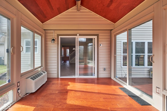 unfurnished sunroom featuring an AC wall unit, wooden ceiling, and vaulted ceiling