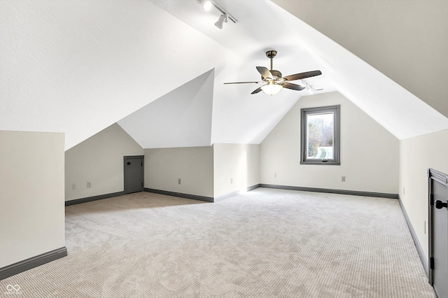 additional living space featuring ceiling fan, light colored carpet, and lofted ceiling